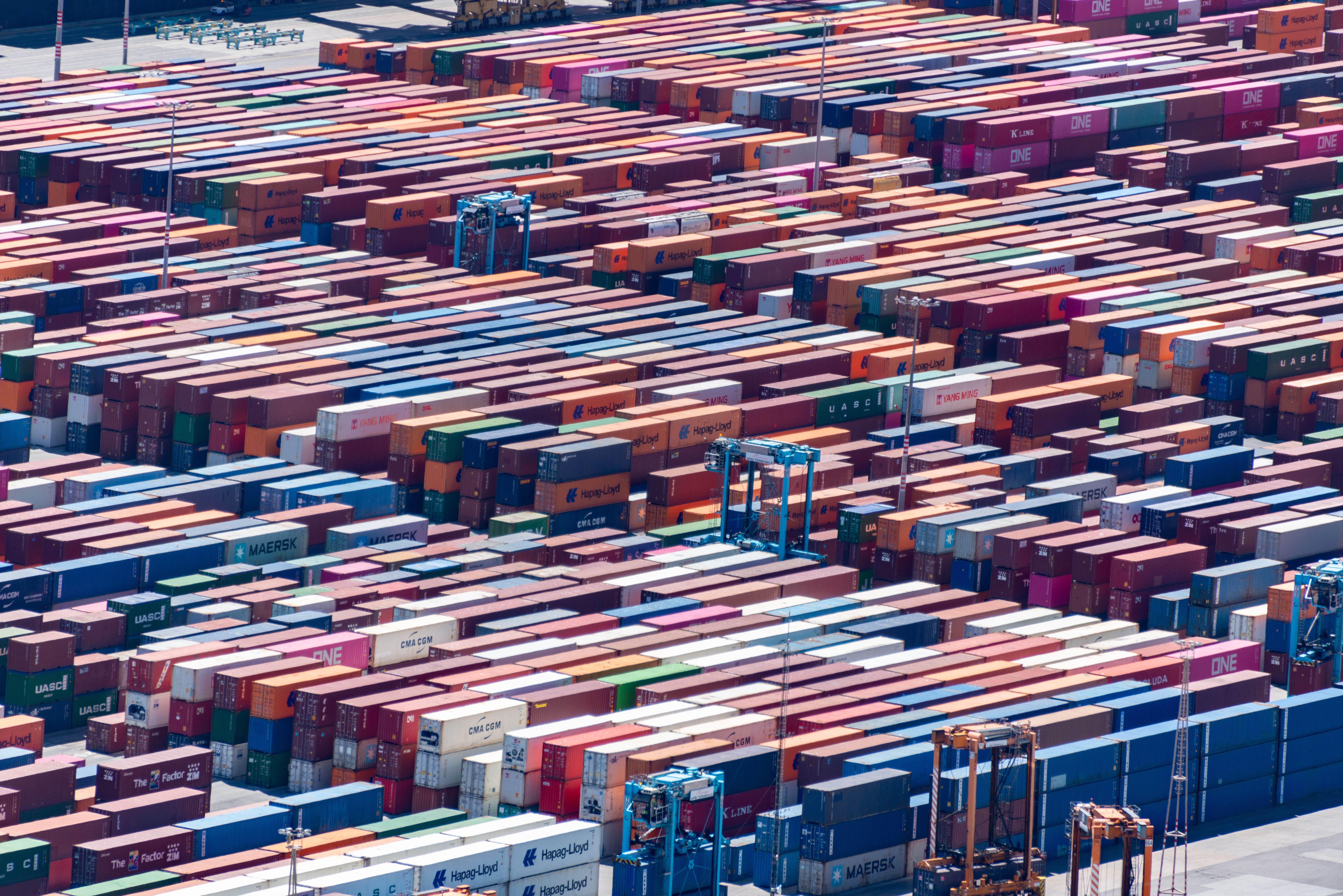 Aerial view of a busy container port and shipping lanes.